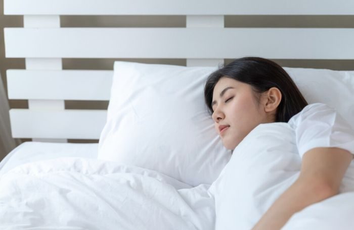 Tidur menyamping bisa jadi alternatif nyaman selain posisi fetal. Posisi ini membantu menjaga postur tubuh tetap netral dan mengurangi tekanan pada perut.
