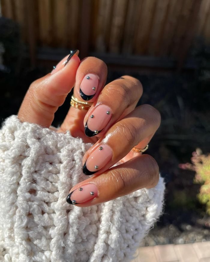 Sentuhan gems kecil bisa membuat nail art terlihat lebih glam. Perpaduan warna gelap dan aksen silver menciptakan kesan edgy.