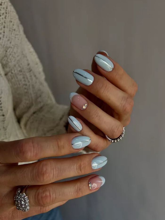 Garis metallic memberikan sentuhan modern pada kuku pastel. Detail kecil yang bikin tampilan jadi lebih edgy.