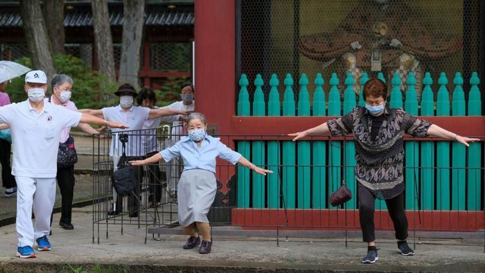 This picture taken on June 16, 2021 shows people taking part in a morning 'radio taiso' exercise in the precincts of Nezu Shrine in Tokyo. - It might not make the cut for Olympians at Tokyo 2020, but each day in Japan's parks, schools and offices millions perform the country's most popular stretching routine: radio taiso.
- TO GO WITH Oly-2020-2021-Japan-health-exercise-virus-taiso,FOCUS by Ayaka McGill and Katie Forster (Photo by Kazuhiro NOGI / AFP) / TO GO WITH Oly-2020-2021-Japan-health-exercise-virus-taiso,FOCUS by Ayaka McGill and Katie Forster (Photo by KAZUHIRO NOGI/AFP via Getty Images) This picture taken on June 16, 2021 shows people taking part in a morning 'radio taiso' exercise in the precincts of Nezu Shrine in Tokyo. - It might not make the cut for Olympians at Tokyo 2020, but each day in Japan's parks, schools and offices millions perform the country's most popular stretching routine: radio taiso.
- TO GO WITH Oly-2020-2021-Japan-health-exercise-virus-taiso,FOCUS by Ayaka McGill and Katie Forster (Photo by Kazuhiro NOGI / AFP) / TO GO WITH Oly-2020-2021-Japan-health-exercise-virus-taiso,FOCUS by Ayaka McGill and Katie Forster (Photo by KAZUHIRO NOGI/AFP via Getty Images)