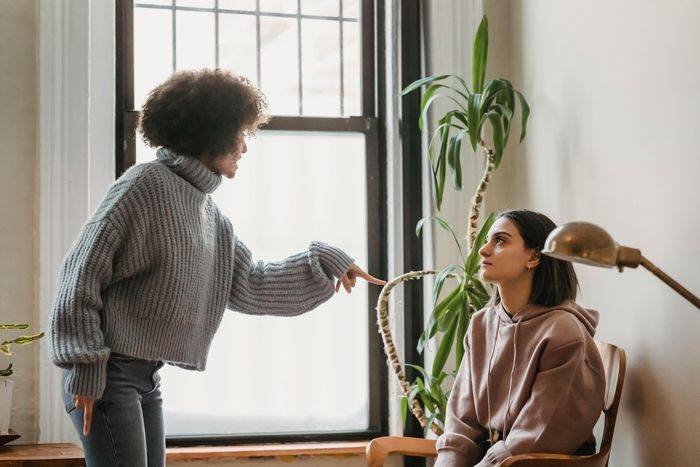 Perempuan menunjuk orang lain saat terjadi masalah